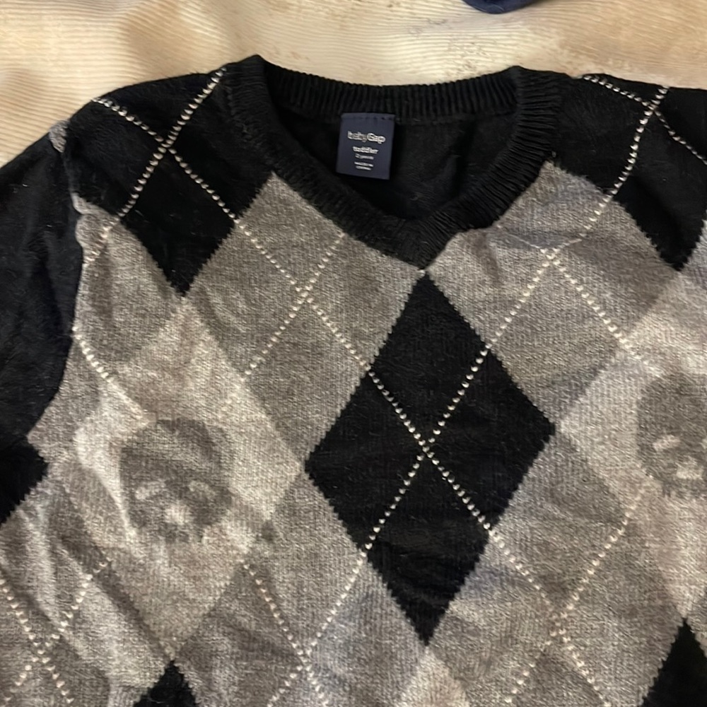 Black and gray long sleeve sweater with skull design.